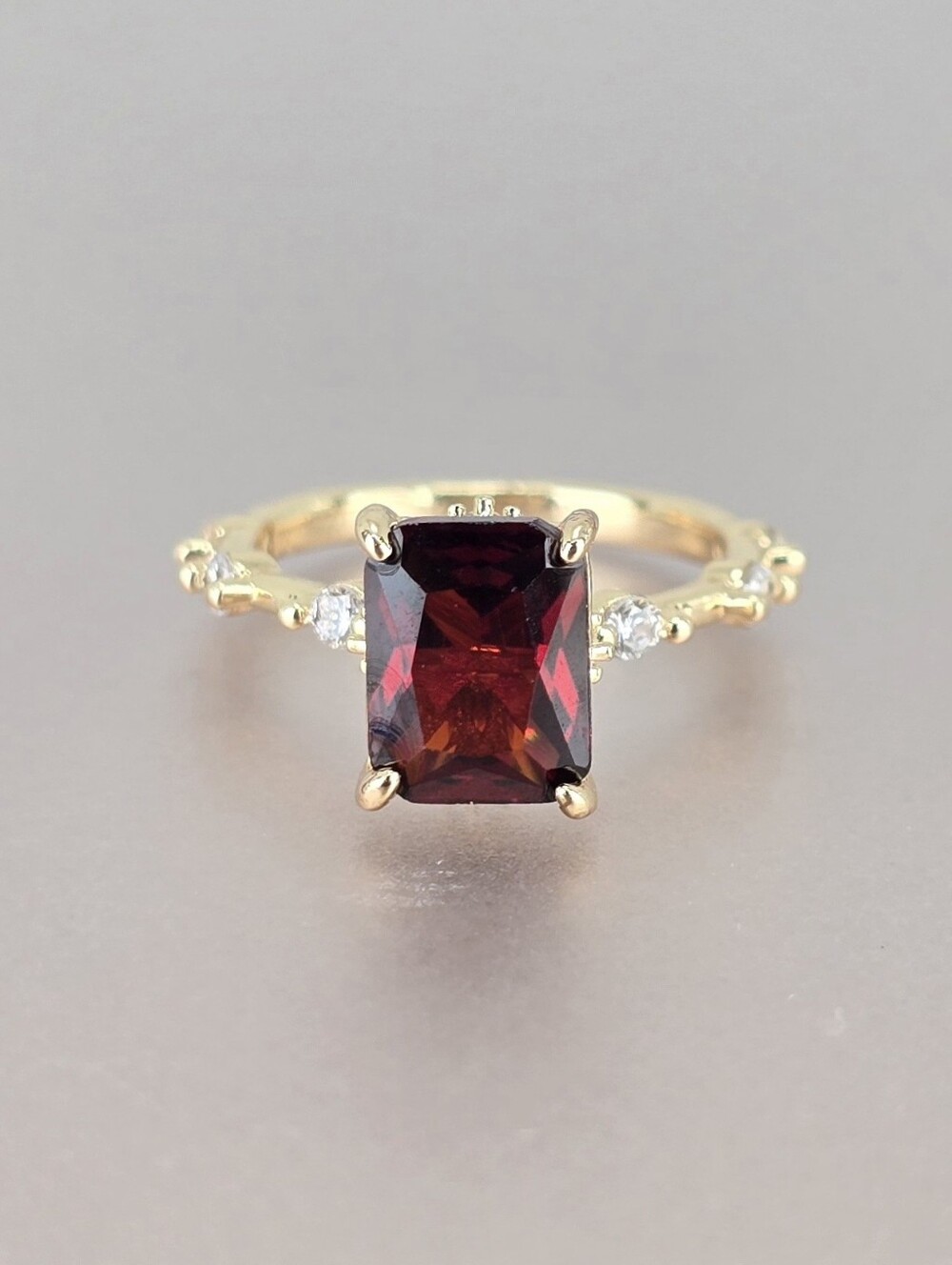 Gold Ring with Deep Red Radiant-Cut Gemstone and Accent Stones